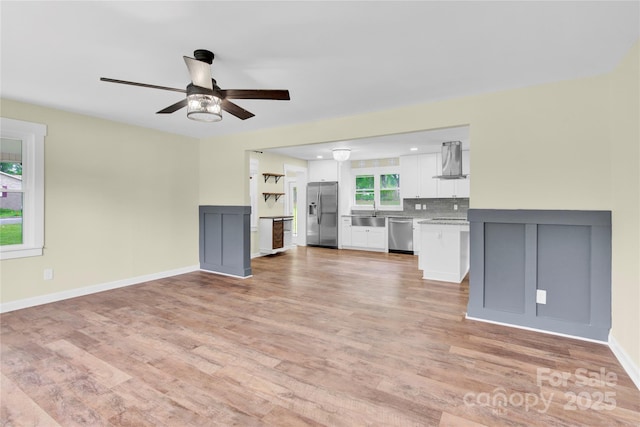 1501 E Church St, Cherryville, NC 28021 - unfurnished living room with a ceiling fan, light wood-type flooring, baseboards, and a sink