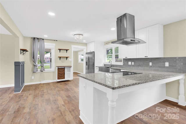 1501 E Church St, Cherryville, NC 28021 - kitchen with stainless steel fridge with ice dispenser, island exhaust hood, a peninsula, light stone counters, and white cabinets