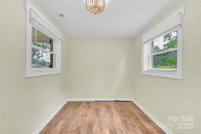 1501 E Church St, Cherryville, NC 28021 - spare room featuring baseboards, healthy amount of natural light, a chandelier, and wood finished floors
