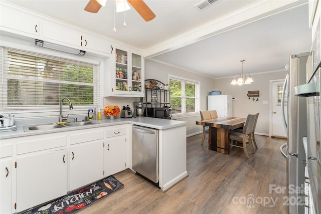 kitchen featuring a sink, appliances with stainless steel finishes, crown molding, wood finished floors, and ceiling fan