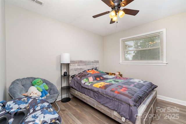 bedroom featuring wood finished floors, baseboards, and a ceiling fan