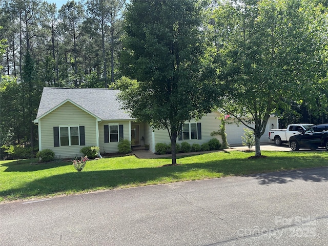 view of front of home with a front lawn, a shingled roof, concrete driveway, and a garage