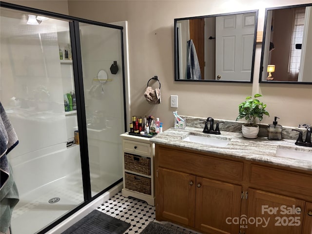 bathroom featuring a stall shower, double vanity, and tile patterned floors