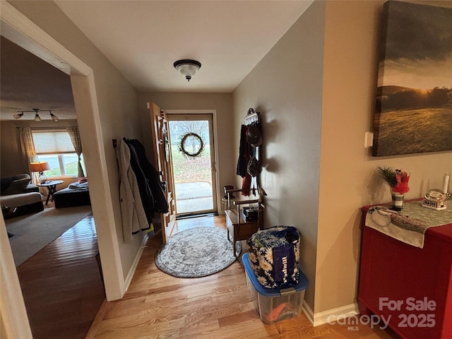 foyer featuring light wood-style flooring and baseboards