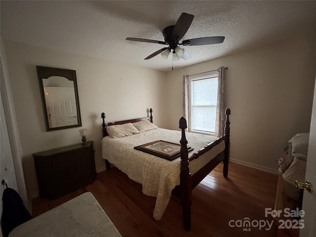 bedroom with wood finished floors, baseboards, a textured ceiling, and a ceiling fan