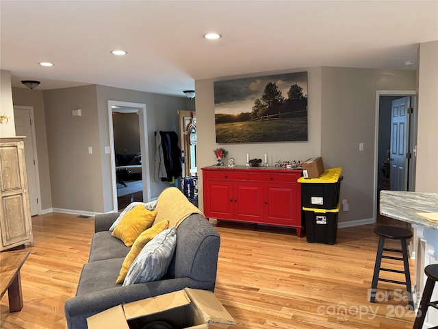 living room with light wood-style floors, recessed lighting, and baseboards