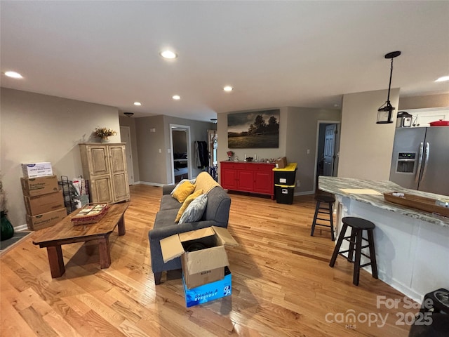 living room with light wood-type flooring, recessed lighting, and baseboards