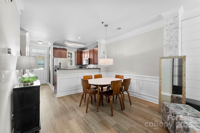2485 Shanklin Ln, Denver, NC 28037 - dining space featuring crown molding, light wood-style flooring, a decorative wall, a wainscoted wall, and recessed lighting