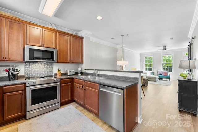 2485 Shanklin Ln, Denver, NC 28037 - kitchen with appliances with stainless steel finishes, a sink, ornamental molding, a peninsula, and open floor plan
