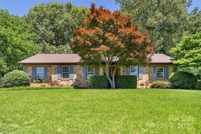 view of front facade featuring brick siding, crawl space, and a front yard