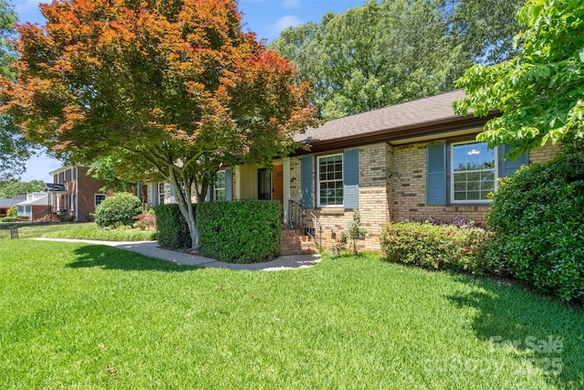 view of front of home featuring brick siding and a front lawn
