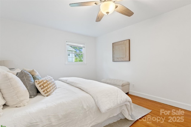 bedroom featuring wood finished floors, baseboards, and a ceiling fan