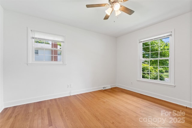 unfurnished room with baseboards, light wood-type flooring, and a ceiling fan