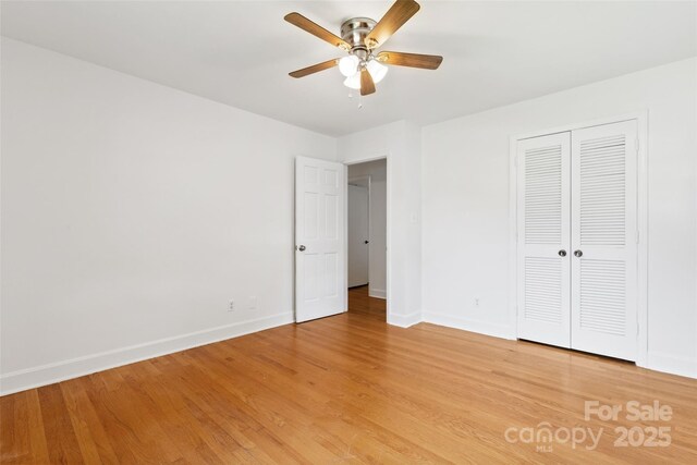 unfurnished bedroom with baseboards, light wood finished floors, a closet, and a ceiling fan