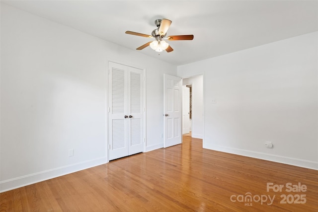 unfurnished bedroom with baseboards, a closet, light wood finished floors, and a ceiling fan