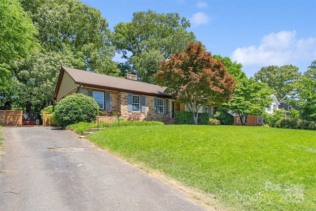 ranch-style house with a chimney and brick siding