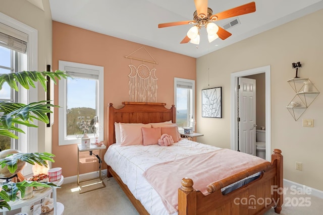 143 Wildflower Ln, Sugar Mountain, NC 28604 - bedroom featuring baseboards, light carpet, connected bathroom, and ceiling fan