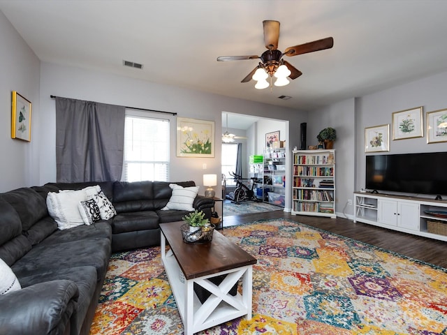 living area featuring a ceiling fan, wood finished floors, and baseboards