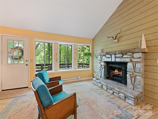76 Shirley Dr, Maggie Valley, NC 28751 - living area featuring wood walls, a stone fireplace, wood finished floors, baseboard heating, and high vaulted ceiling
