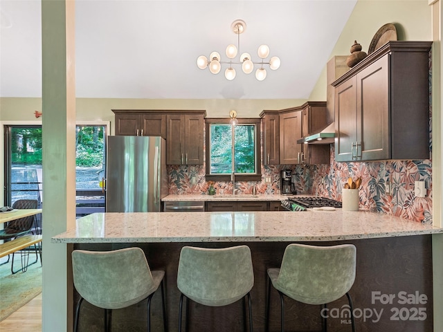 76 Shirley Dr, Maggie Valley, NC 28751 - kitchen featuring stainless steel appliances, a sink, dark brown cabinets, light stone counters, and vaulted ceiling