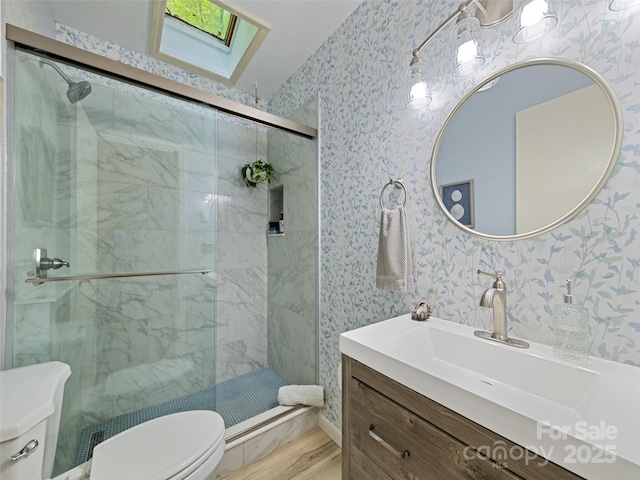 76 Shirley Dr, Maggie Valley, NC 28751 - bathroom featuring toilet, vanity, a stall shower, wallpapered walls, and a skylight