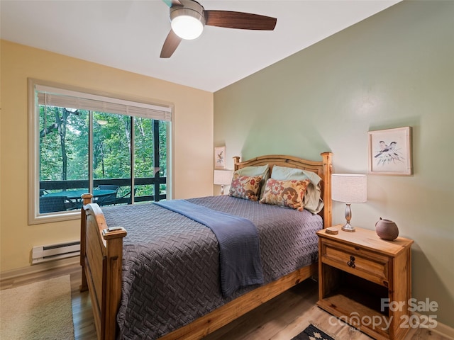 76 Shirley Dr, Maggie Valley, NC 28751 - bedroom with wood finished floors, baseboard heating, a ceiling fan, and access to exterior