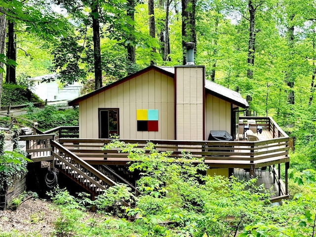 76 Shirley Dr, Maggie Valley, NC 28751 - view of home's exterior featuring a wooden deck, stairs, a wooded view, and a chimney