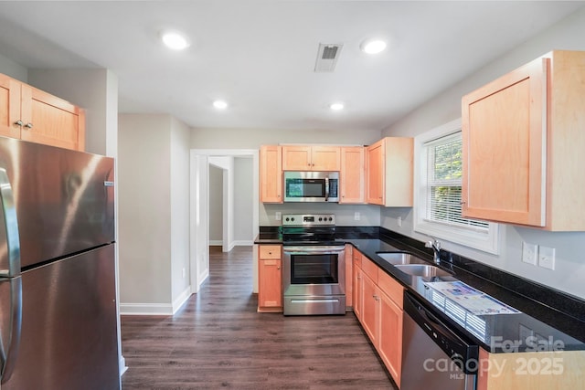 668 Smith St, Kannapolis, NC 28083 - kitchen with appliances with stainless steel finishes, a sink, light brown cabinets, dark countertops, and dark wood-style floors