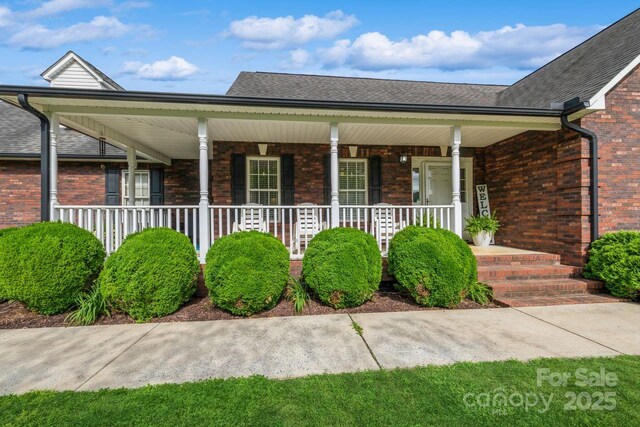 8520 Wright Rd, Kannapolis, NC 28081 - view of front of house with a porch, brick siding, and a shingled roof
