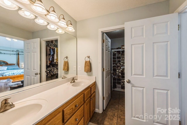 8520 Wright Rd, Kannapolis, NC 28081 - ensuite bathroom with double vanity, tile patterned flooring, a spacious closet, and a textured ceiling