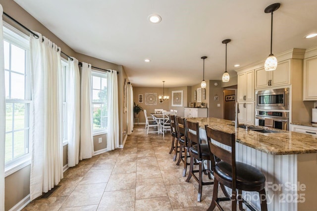8520 Wright Rd, Kannapolis, NC 28081 - kitchen with cream cabinetry, appliances with stainless steel finishes, baseboards, a kitchen breakfast bar, and recessed lighting