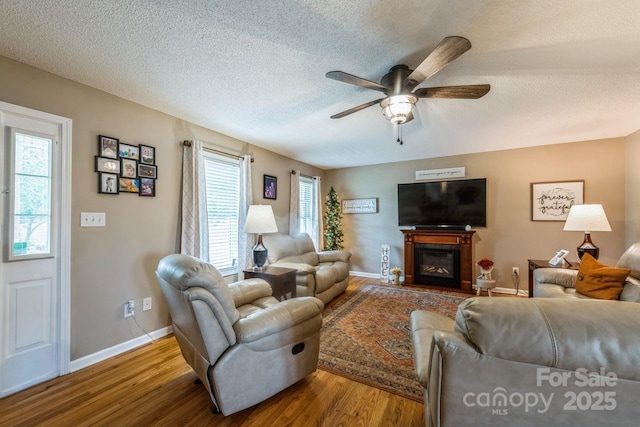 8520 Wright Rd, Kannapolis, NC 28081 - living area with wood finished floors, a ceiling fan, a textured ceiling, a glass covered fireplace, and baseboards