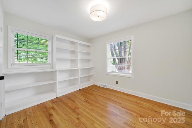empty room with light wood-style floors and baseboards