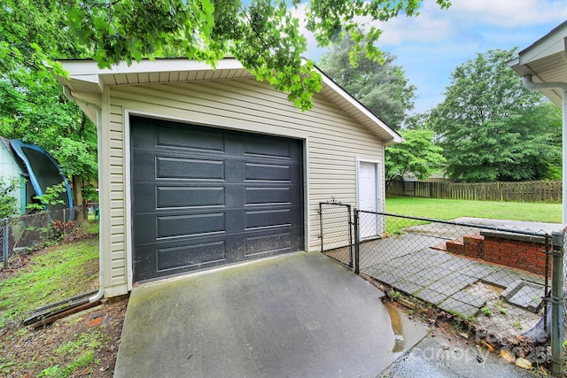 detached garage with a gate and driveway