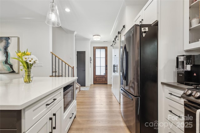 324 Elm St, Belmont, NC 28012 - kitchen featuring black appliances, light wood finished floors, white cabinetry, glass insert cabinets, and decorative light fixtures