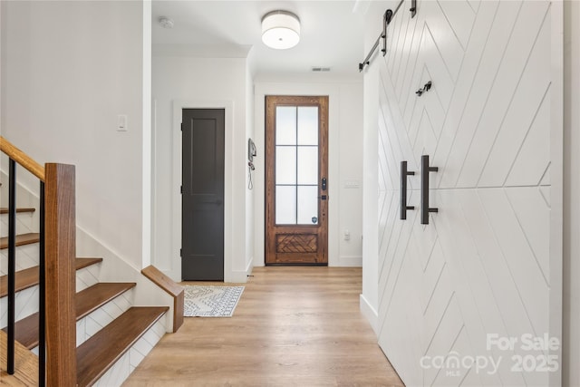 324 Elm St, Belmont, NC 28012 - doorway with light wood-style floors, a barn door, stairs, and baseboards