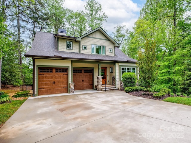 craftsman house featuring driveway, a garage, a shingled roof, and a chimney