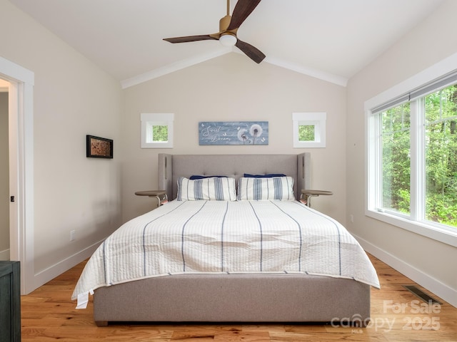 bedroom with lofted ceiling, wood finished floors, baseboards, and a ceiling fan