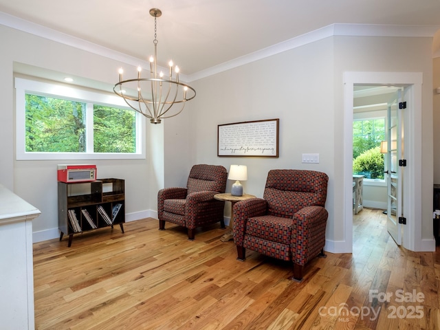 sitting room featuring light wood-style floors, a chandelier, baseboards, and ornamental molding