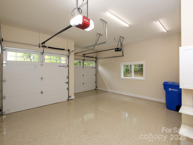 garage featuring a garage door opener and baseboards