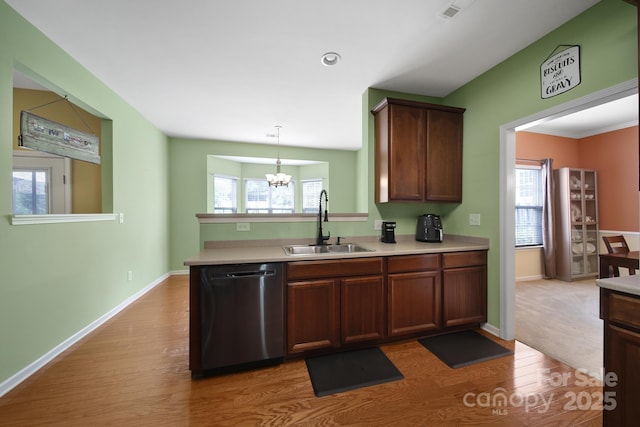 2017 White Cedar Ln, Waxhaw, NC 28173 - kitchen with dishwashing machine, a sink, light countertops, and light wood-type flooring