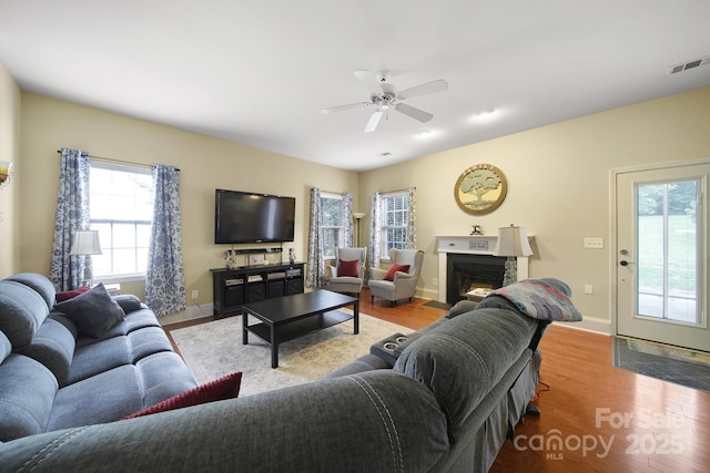 2017 White Cedar Ln, Waxhaw, NC 28173 - living area featuring wood finished floors, a warm lit fireplace, ceiling fan, and baseboards