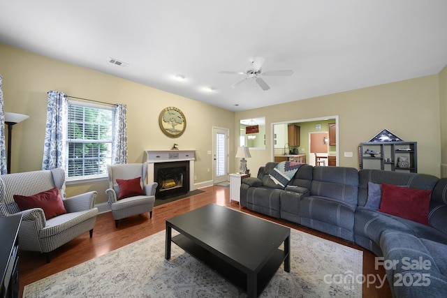 2017 White Cedar Ln, Waxhaw, NC 28173 - living room featuring wood finished floors, ceiling fan, a fireplace with flush hearth, and baseboards