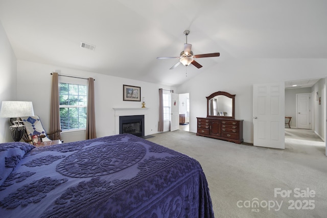 2017 White Cedar Ln, Waxhaw, NC 28173 - bedroom featuring lofted ceiling, multiple windows, light carpet, a fireplace, and ceiling fan