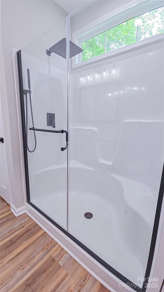 bathroom with a shower stall and wood finished floors