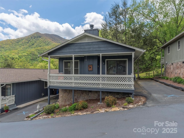 336 Stoney Ridge Loop, Maggie Valley, NC 28751 - view of front of home with board and batten siding, a mountain view, a chimney, and asphalt driveway