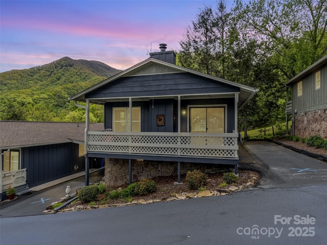336 Stoney Ridge Loop, Maggie Valley, NC 28751 - view of front of home featuring a mountain view, board and batten siding, a chimney, covered porch, and driveway