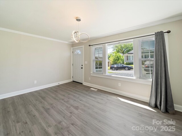 83 Woodsdale Pl SE, Concord, NC 28025 - unfurnished dining area with ornamental molding, baseboards, a chandelier, and wood finished floors