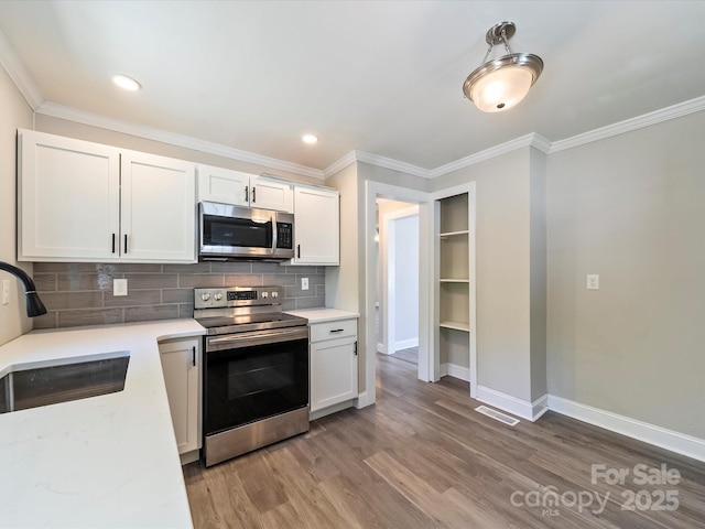 83 Woodsdale Pl SE, Concord, NC 28025 - kitchen with stainless steel appliances, a sink, baseboards, backsplash, and light wood-type flooring