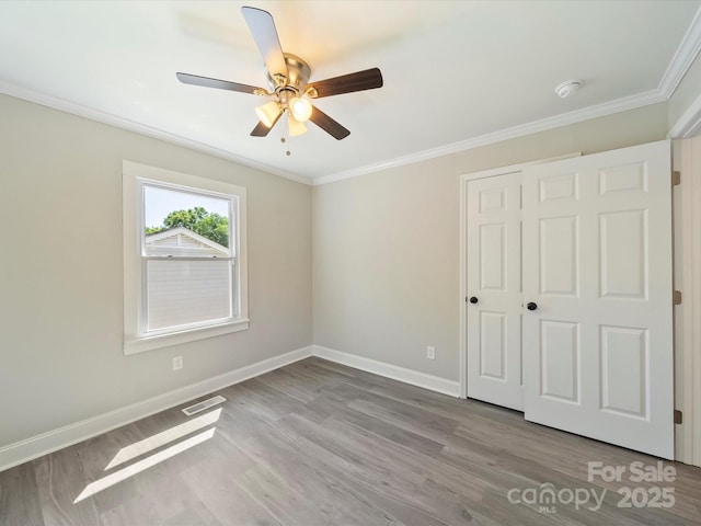 83 Woodsdale Pl SE, Concord, NC 28025 - unfurnished bedroom featuring ornamental molding, baseboards, wood finished floors, and a ceiling fan